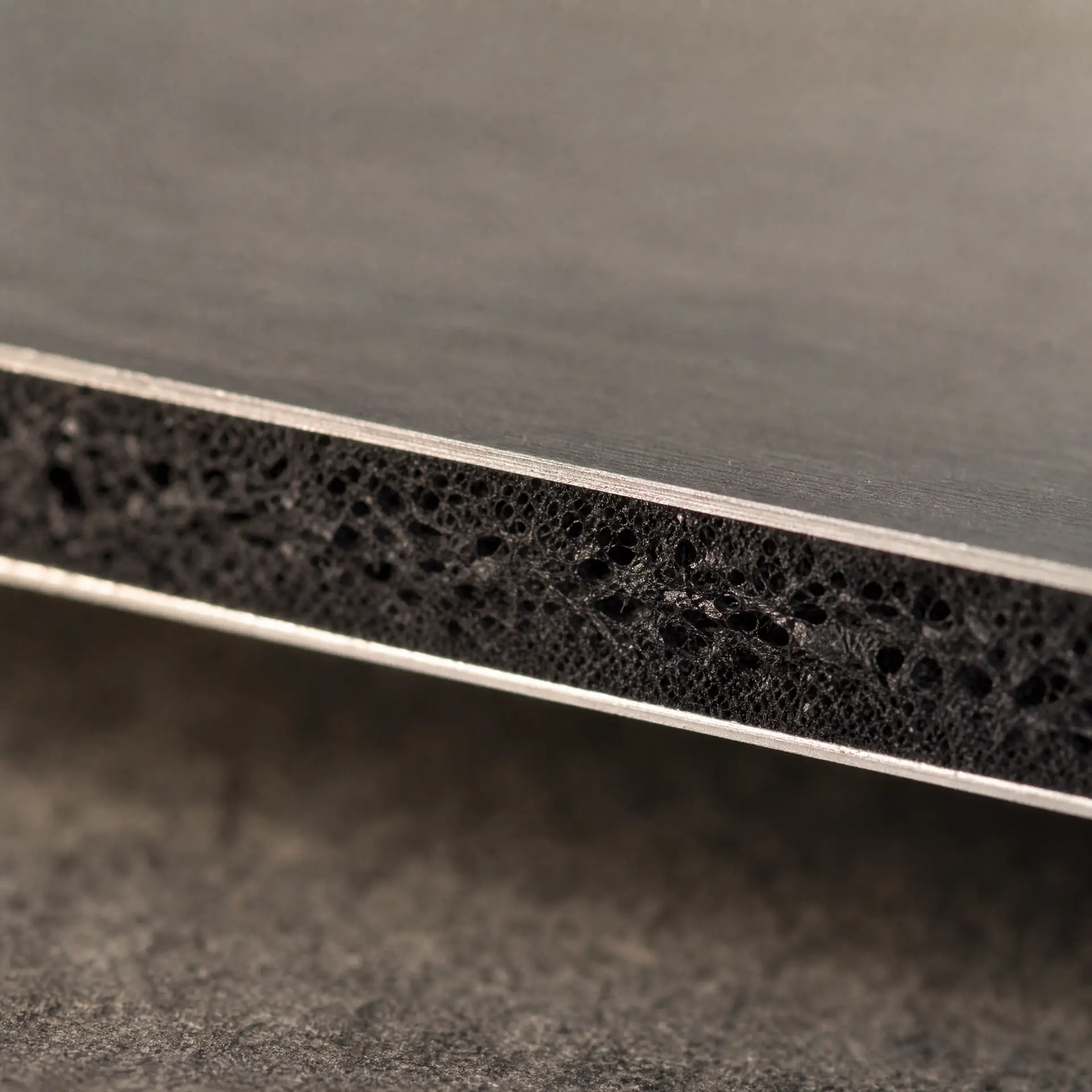 Cut edge of an aluminium composite panel, the two metal skins and the polyethylene core visible